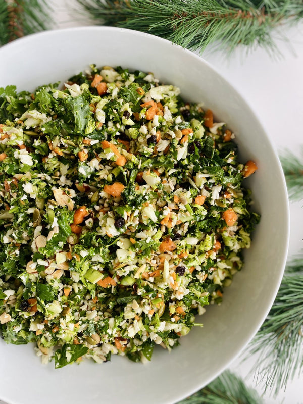 Raw detox salad with broccoli, cauliflower, carrot, kale, parsley, lemon, currants, almonds & seeds