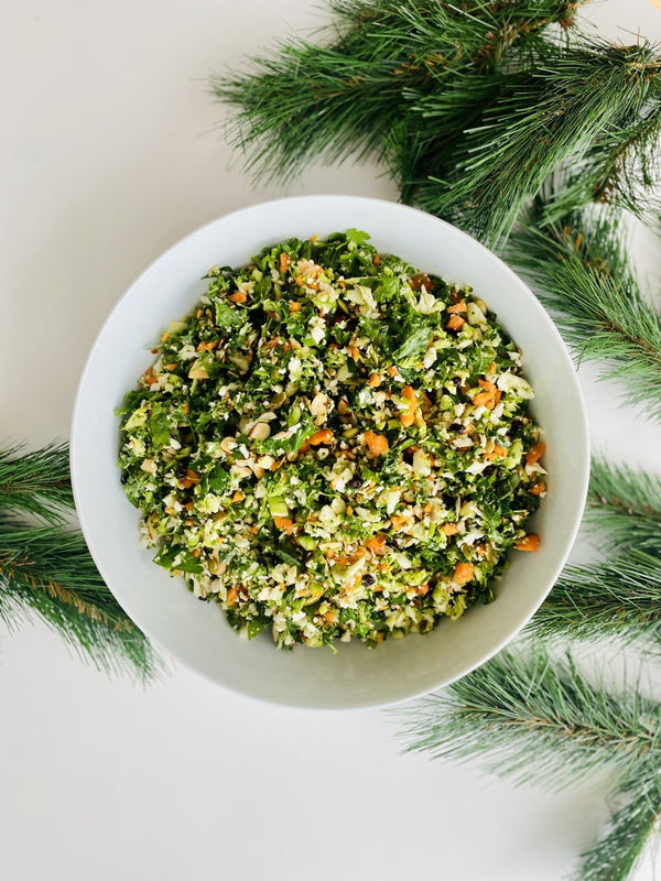 Raw detox salad with broccoli, cauliflower, carrot, kale, parsley, lemon, currants, almonds & seeds